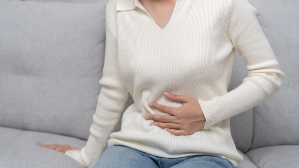 お腹をおさえる女性